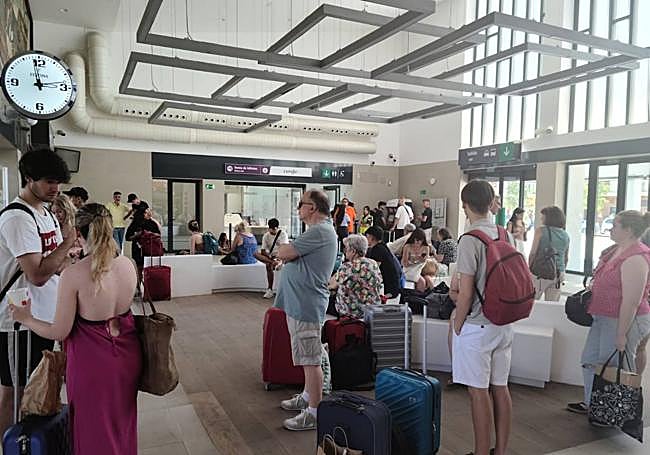 Pasajeros del tren afectado por la avería esperando en el vestíbulo de la estación de Badajoz.