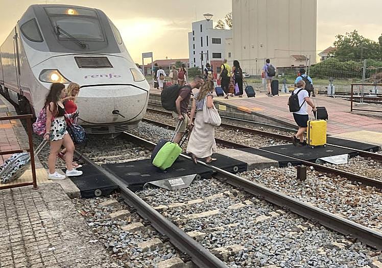 Imagen principal - Los pasajeros con destino a Cáceres y Plasencia han tomado otro tren a las 21.00 horas; el Alvia averiado junto al Talgo en el que han reubicado a los usuarios de Mérida y Badajoz y el interior del Talgo. 