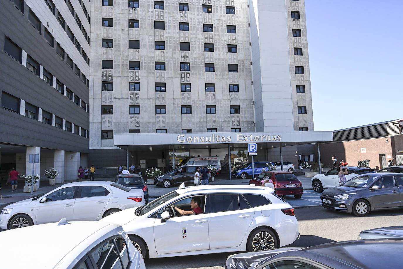 Vehículos aparcados en doble fila y sobre la acera en las puertas de Consultas Externas, donde más atascos se dan