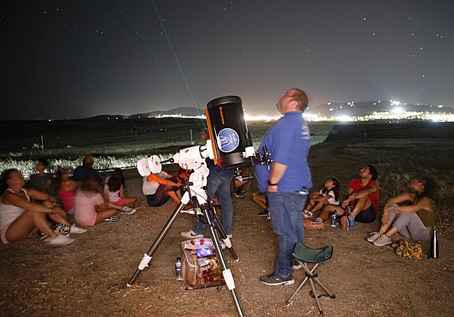 Lorenzo Cordero, de la empresa 'El Cielo de Cáceres', junto al telescopio y participantes.