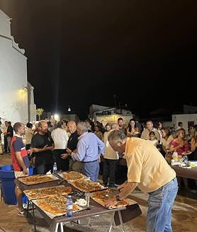 Imagen secundaria 2 - Arriba, imagen de la Virgen de la Luz con las flores ofrecidas por los fieles. Abajo, asistentes a la misa en la parroquia, y posterior degustación de pizzas y tortitas de tagarninas.