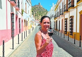 María Julia Marín sujeta una copa de vino con el castillo de Miraflores como telón de fondo.