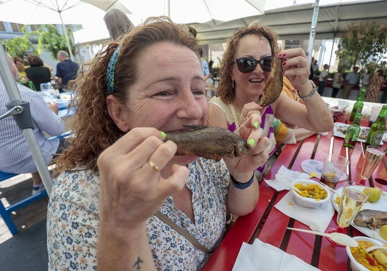 Dos mujeres disfrutan de las tencas en la plaza de Ovando de la localidad de Brozas.