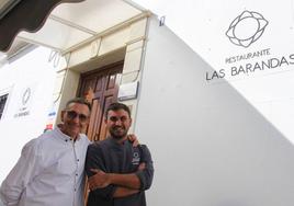 Dos generaciones, Manuel y Fernando Gil, en la fachada de su restaurante en la plaza de la localidad pacense.