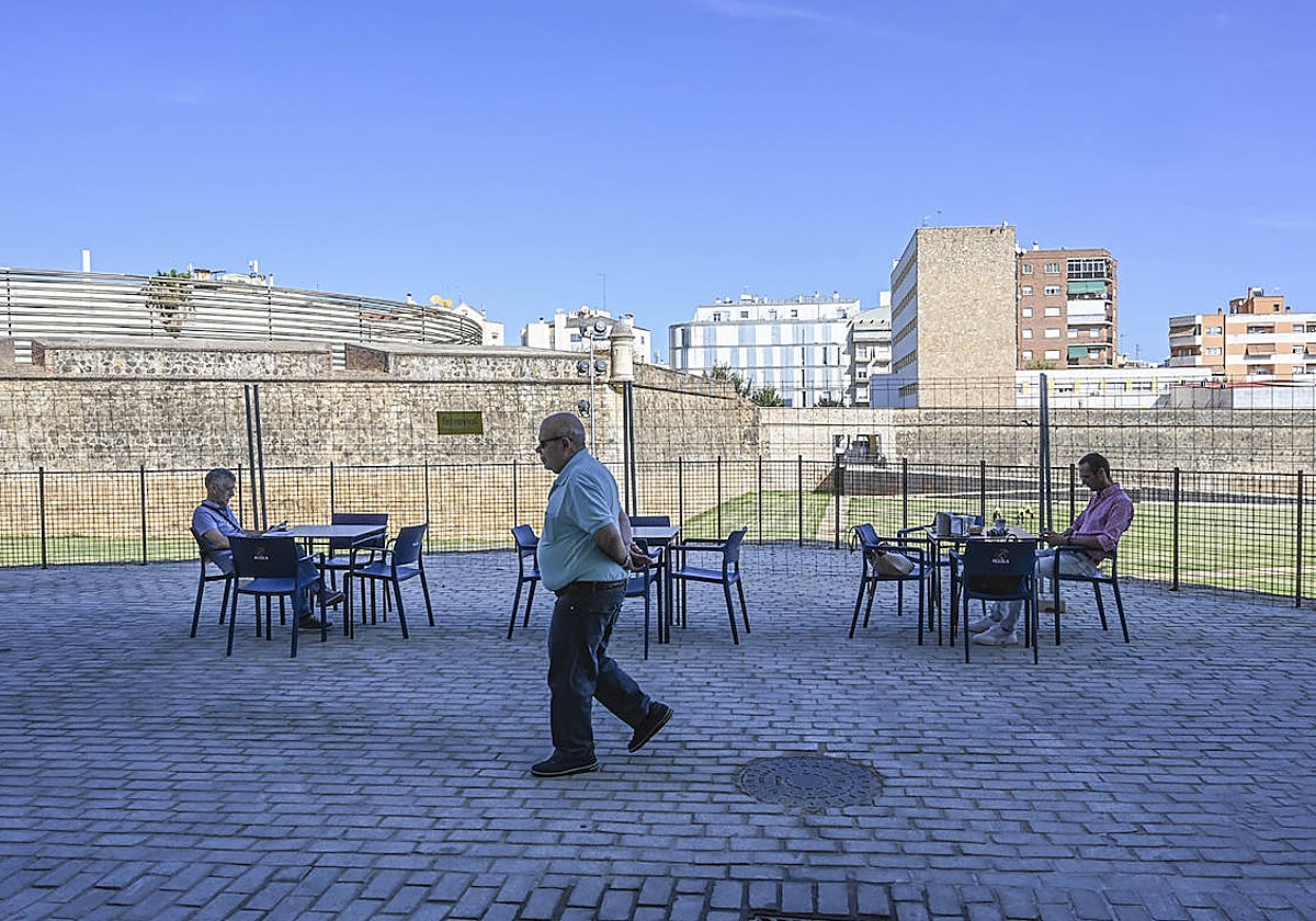 Pacenses sentados en una terraza junto al corredor verde, a la espera de su apertura.