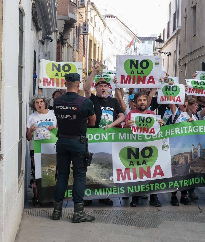 Imagen secundaria 2 - Arriba, el ministro Iceta fotografía la estatua de San Jorge. Debajo, los ministros a su llegada a la plaza de San Jorge, donde compartían espacio con los turistas. En la imagen inferior, protesta de Salvemos la Montaña..