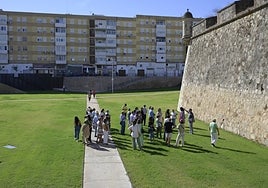 Participantes en la visita guiada mirando una zona con impactos de cañón