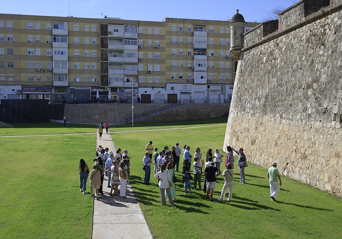 Participantes en la visita guiada mirando una zona con impactos de cañón.