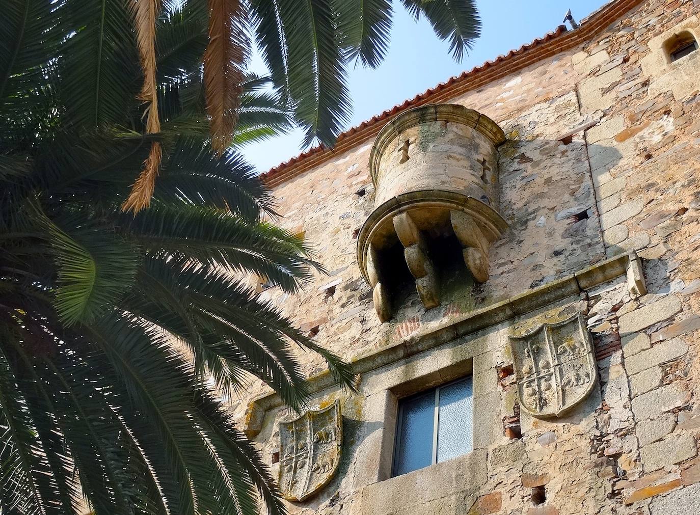 Bajo el matacán están los escudos de Ovando-Mogollón (cruz de Calatrava con conchas de peregrino y dos osos).