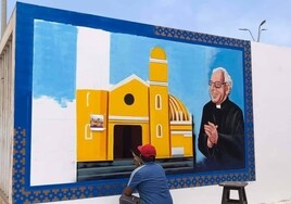 Un hombre pinta un mural a Fernando Cintas Rosa en Mala, Perú.