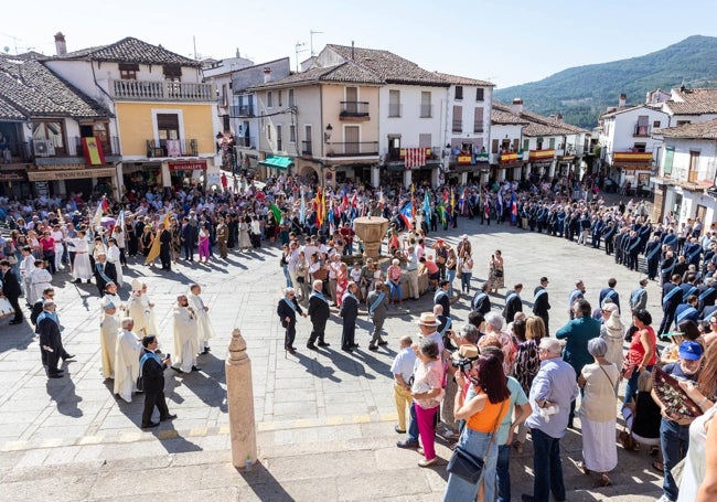 Procesión de la Real Asociación de Caballeros de Santa María de Guadalupe, con la plaza del Monasterio llena de banderas de España y Extremadura en los balcones.