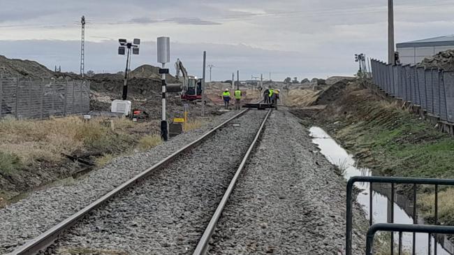 Imagen después - Demolición del paso superior sobre las vías del tren en Navalmoral, junto a una imagen de este lunes, con los escombros del paso superior retirados.