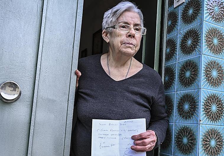 Juana Redondo en la puerta de su domicilio con la factura que le dejó el supuesto estafador.