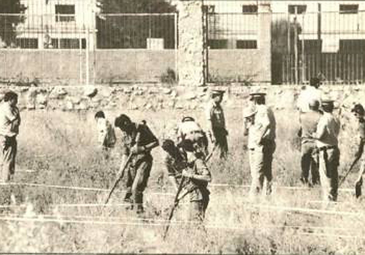 La policía buscando pruebas en el solar tras el crimen.