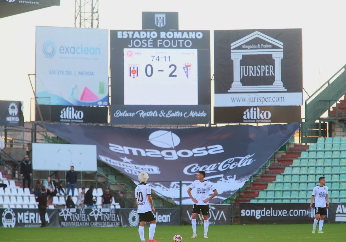 Pensativos los jugadores del Mérida con el marcador de 0-2 al fondo.