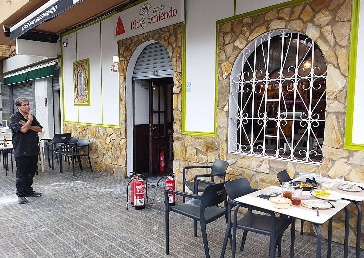 Imagen secundaria 1 - Los bomberos durante la intervención, los extintores en la puerta, y la freidora, en una ventana del bar.
