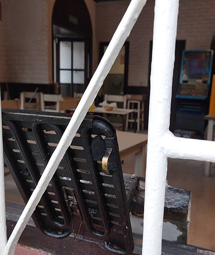 Imagen secundaria 2 - Los bomberos durante la intervención, los extintores en la puerta, y la freidora, en una ventana del bar.