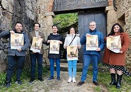 Los participantes en la presentación del evento posan a las puertas del castillo