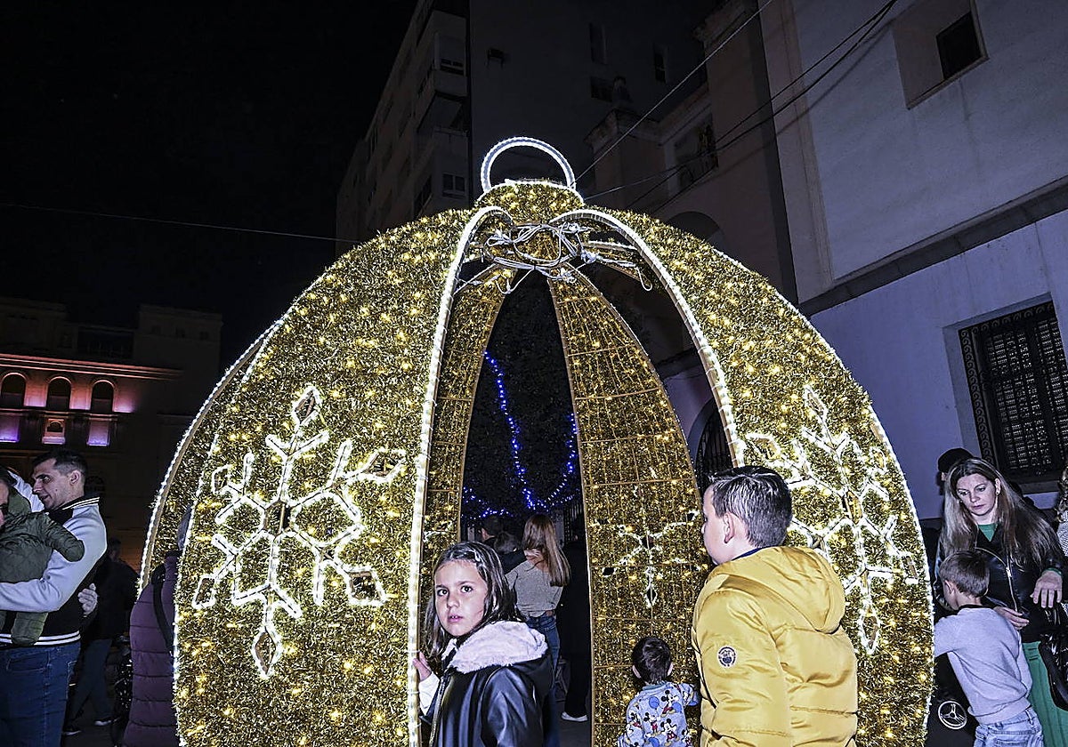 Niños entran en alguna de las bolsas navideñas iluminadas.