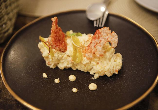 Ensaladilla ibérica de patatas asadas al carbón, piparras y crujiente de tapioca con pimentón de la Vera.