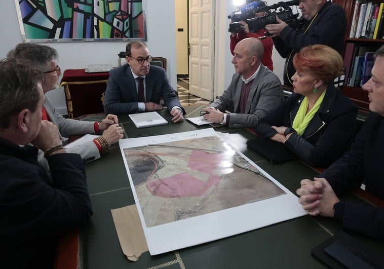 El alcalde, Rafael Mateos, junto a los promotores del proyecto budista, y el plano de los terrenos.