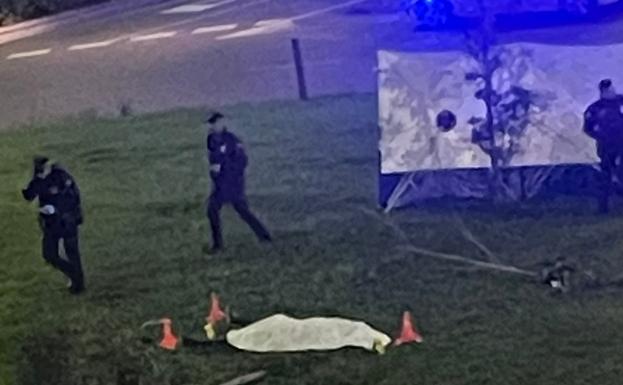 Policías junto al cuerpo, tendido en el interior de la glorieta. 