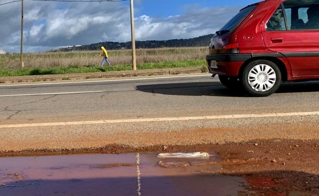 Un hombre camina al borde de la carretera en la avenida de Juan Pablo II. 