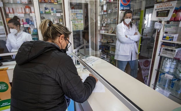 Susana Moreno, vecina de Aldea Moret, firma el escrito en la farmacia de la avenida de la Constitución. 