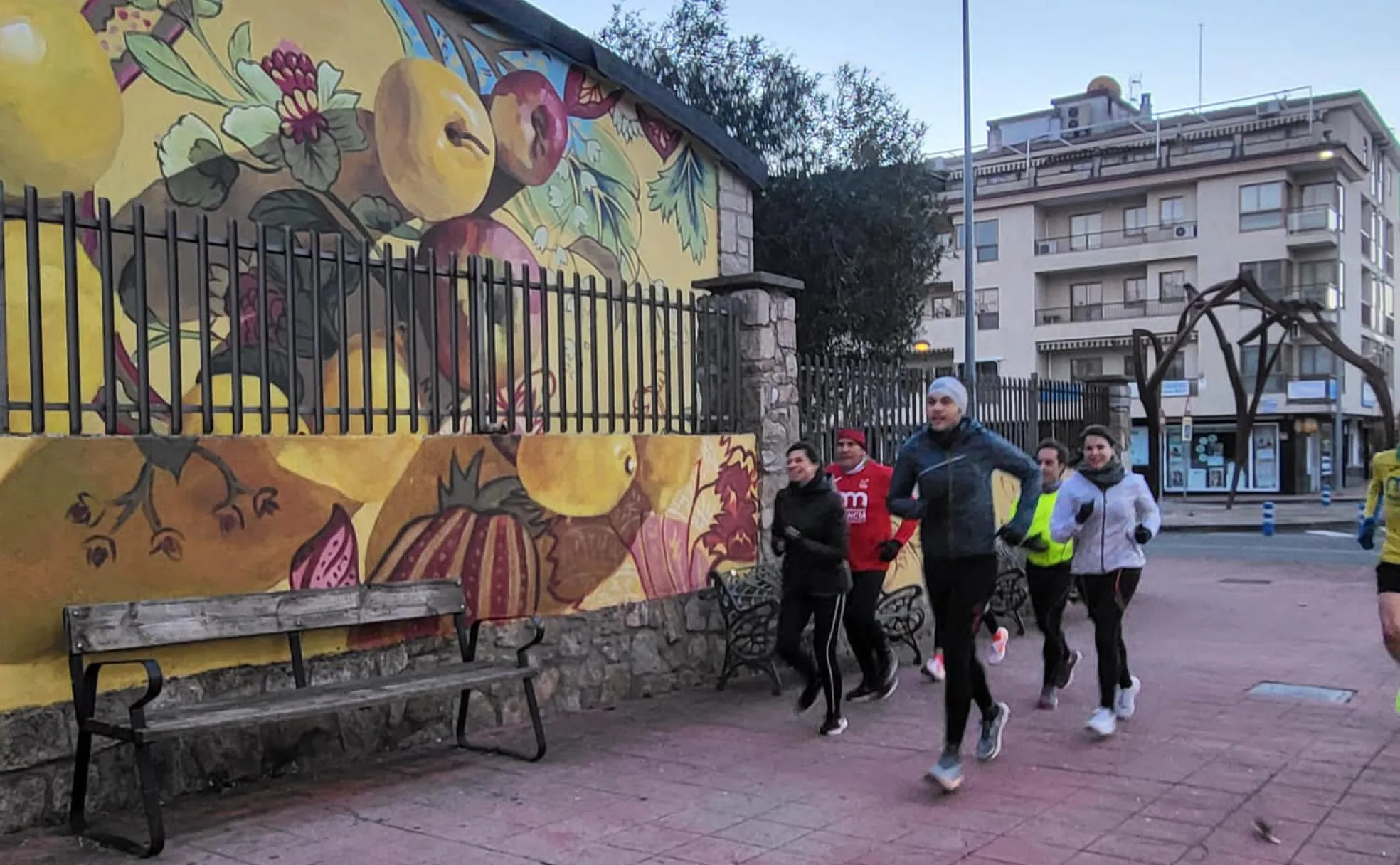 Corredores de Atletas Populares pasan junto al bodegón 'Frutales' de Marta Lapeña. 