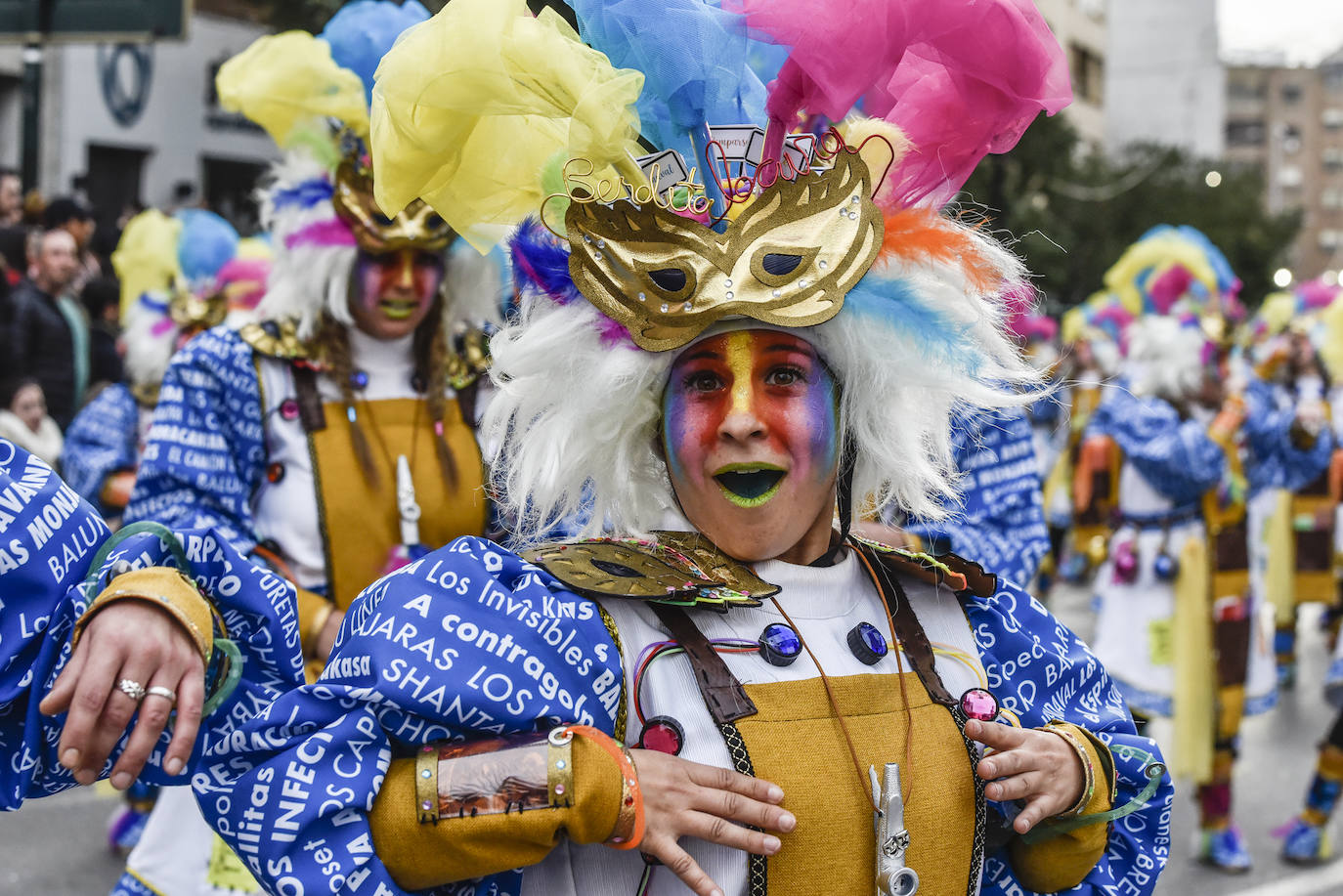 Balumba tiene una propuesta muy original este año, la locura del Carnaval. Son una especie de científicos locos llenos de elementos carnavaleros. Sus camisas llevan impresas los nombres de todas las comparsas y las murgas de la fiesta y en su traje hay detalles propios de un adicto a esta celebración como la turuta o la brillantina. Su gorro simula una peluca de científico loco pero con antifaz y plumas. Además se les ve un cerebro de colores con ideas carnavaleras. Muy divertidos. 