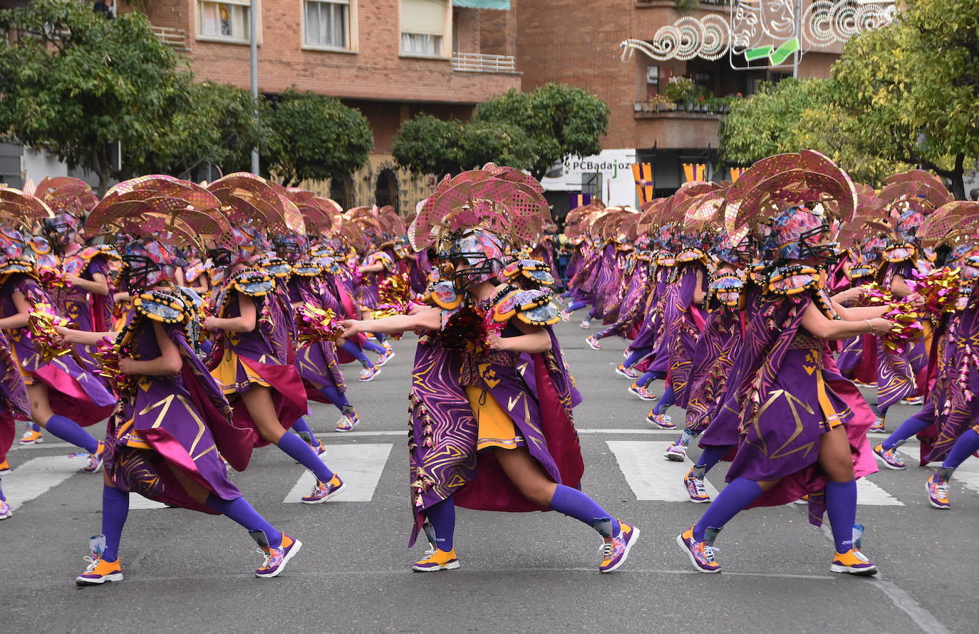En amarillo y morado han desfilado Las Monjas. Como es tradicional en esta comparsa de Torremejía, mezcla dos temáticas en sus trajes, en este caso, el fútbol americano con las justas medievales. Los detalles brillantes de su gorro, siempre muy complejo, les hizo lucirse. El montaje de 2023 recuerda algunas de las mejores propuestas de esta comparsa que sabe lo que es ganar siete veces en Badajoz.