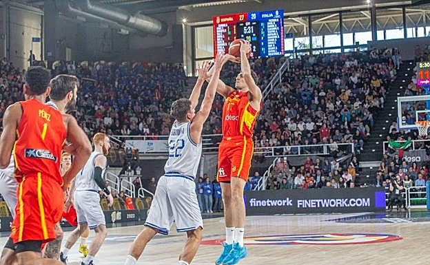 Álex Reyes, que debutó en su ciudad natal con la selección absoluta, intenta un lanzamiento con la oposición de Bortolani. 