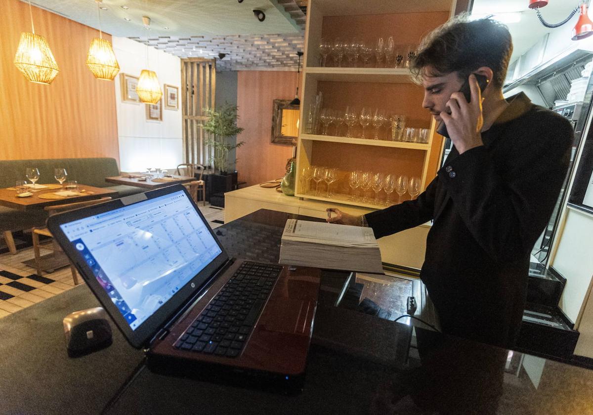 Un trabajador de un restaurante de Cáceres toma nota de una reserva.