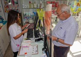 Una farmacéutica atiende a un cliente en una botica de la región.