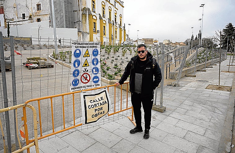 Rafa C. junto a las vallas que impiden la salida. Al fondo, los palés con los bloques de cemento.