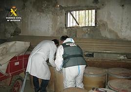 Un guardia civil y un técnico inspeccionan el almacén