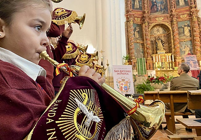 En primer plano, la integrante más joven de la banda infantil de la cofradía del Humilladero.