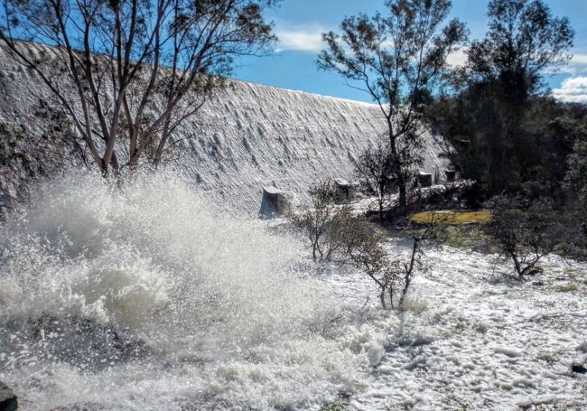 Imagen del pantano de Valdesalor con el agua superando la presa.