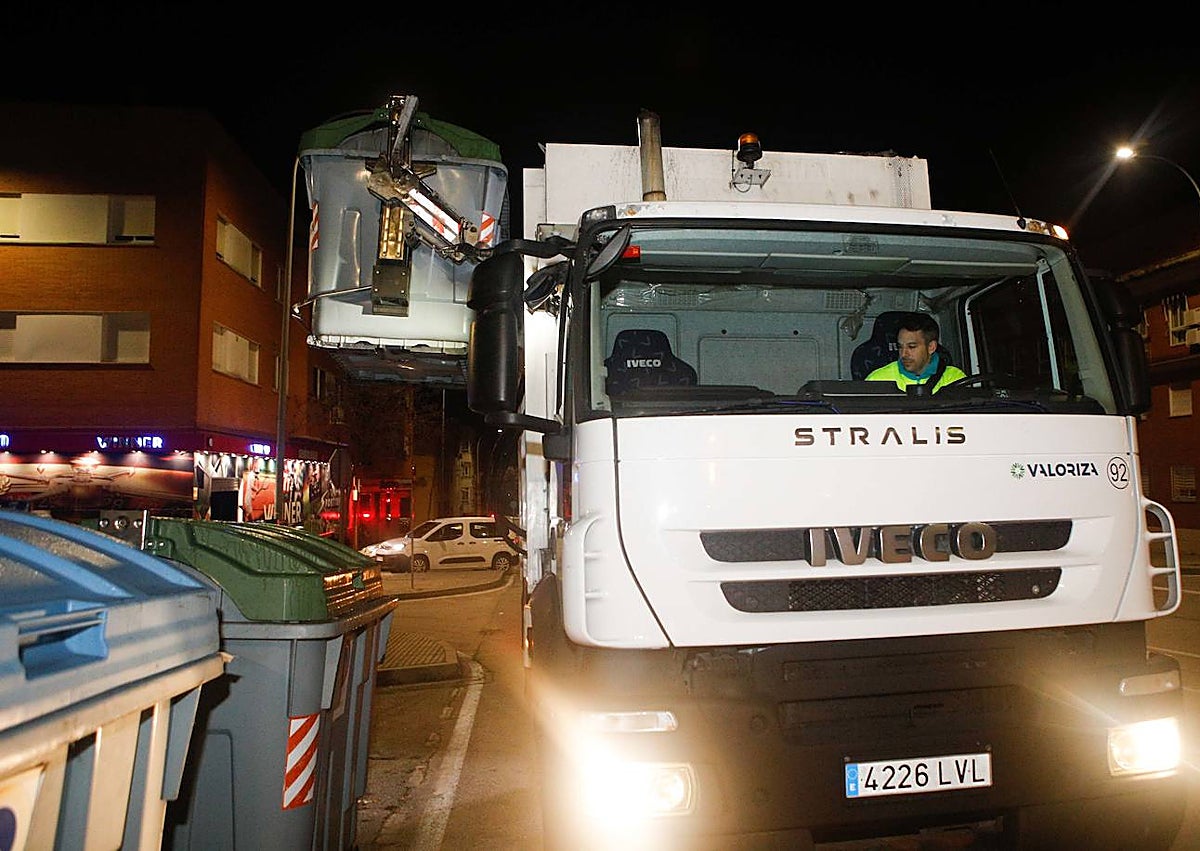 Imagen secundaria 1 - Arriba, foto de familia de los responsables de la empresa y del Ayuntamiento con los trabajadores antes del inicio de la jornada de noche. Abajo, un camión de recogida luce el nombre de la nueva concesionaria. Sobre estas líneas, varios operarios con los uniformes de estreno. 