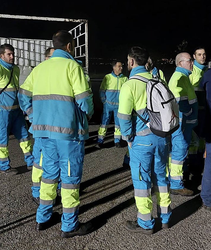 Imagen secundaria 2 - Arriba, foto de familia de los responsables de la empresa y del Ayuntamiento con los trabajadores antes del inicio de la jornada de noche. Abajo, un camión de recogida luce el nombre de la nueva concesionaria. Sobre estas líneas, varios operarios con los uniformes de estreno. 