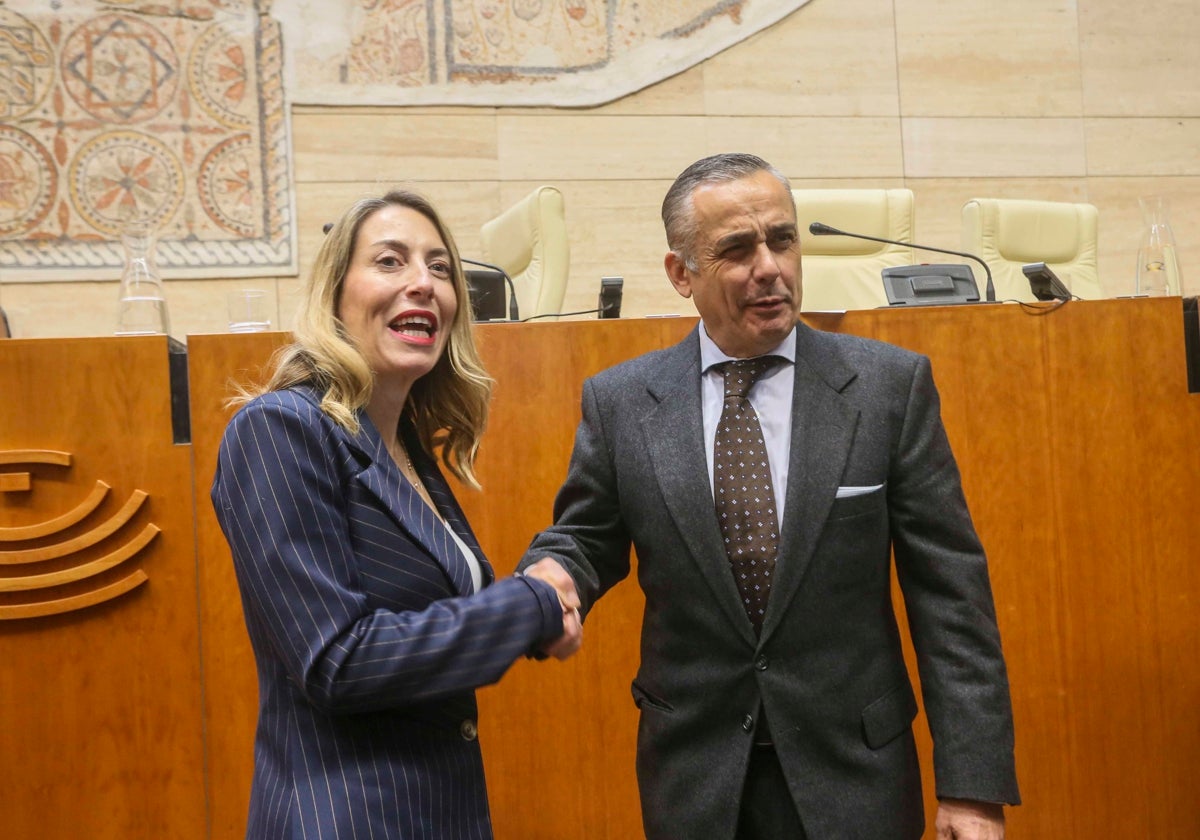 María Guardiola y Ángel Pelayo se saludan tras aprobar sus primeros presupuestos.