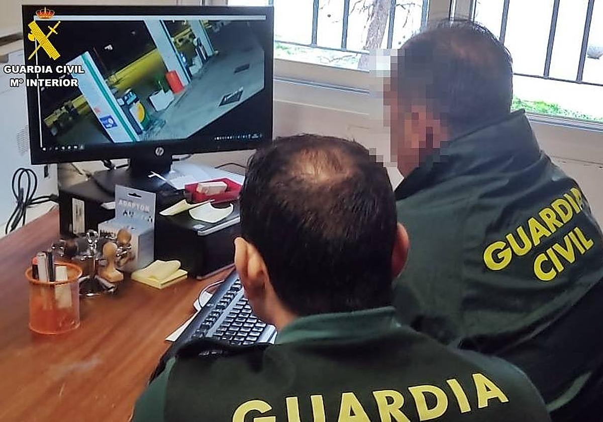 Guardias civiles durante el visionado de las cámaras de videovigilancia de la estación de servicio.