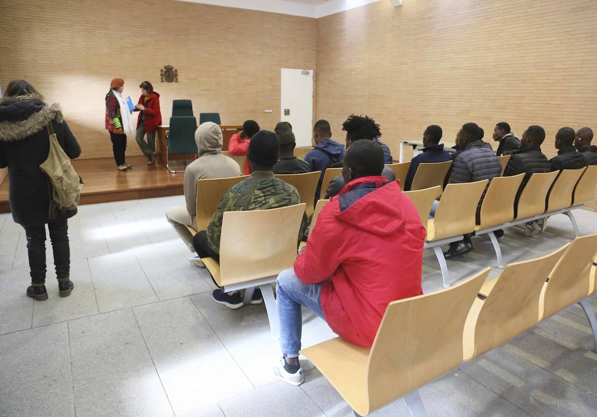 Un grupo de migrantes acogidos en el Prado, ayer en la sala de bodas de los juzgado esperando a la abogada de oficio.