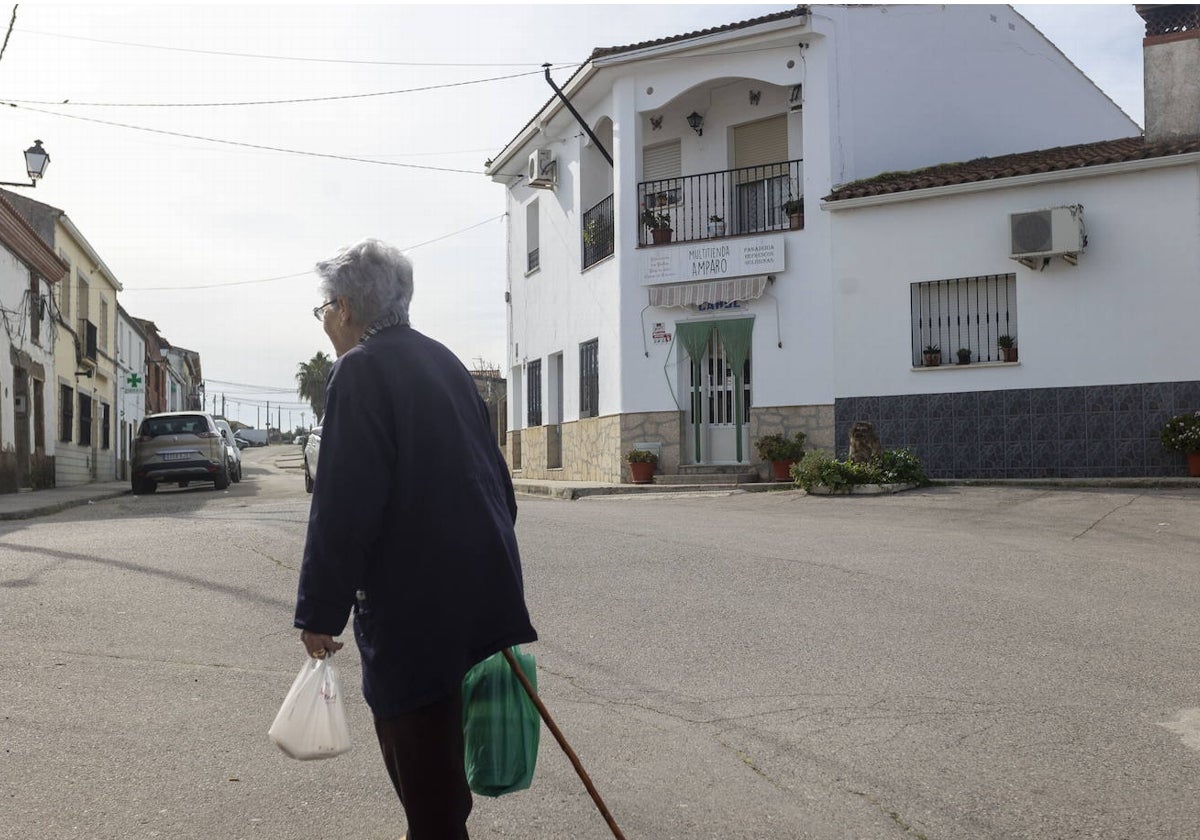 Una anciana paseando por Hinojal tras hacer la compra en una mañana tranquila.