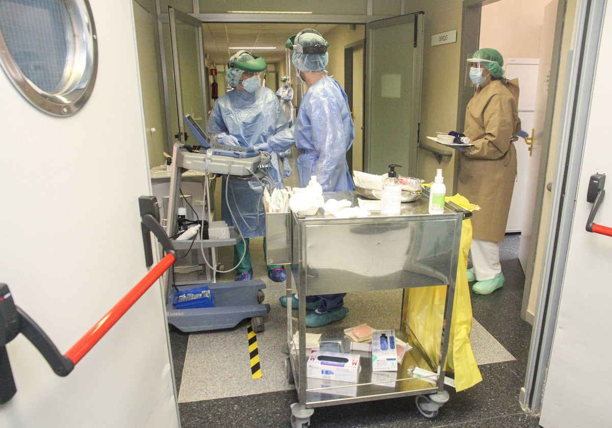 Imagen de archivo de tres sanitarios atendiendo a pacientes con covid.