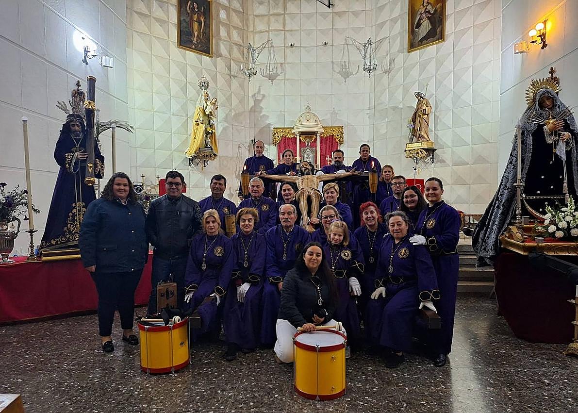 Imagen secundaria 1 - Arriba, momento de la procesión del Domingo de Ramos. Abajo, grupo de portadores y nazarenos de la Hermandad del Cristo de Alconchel, tras la procesión del Lunes Santo.