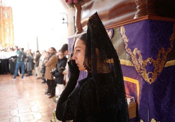 Una penitente llora ante el paso de la imagen del Santísimo Cristo del Calvario.