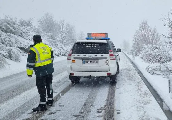 Agentes de la Guardia Civil de Tráficos en una de las carreteras cacereñas afectadas por el temporal de nieve este domingo.