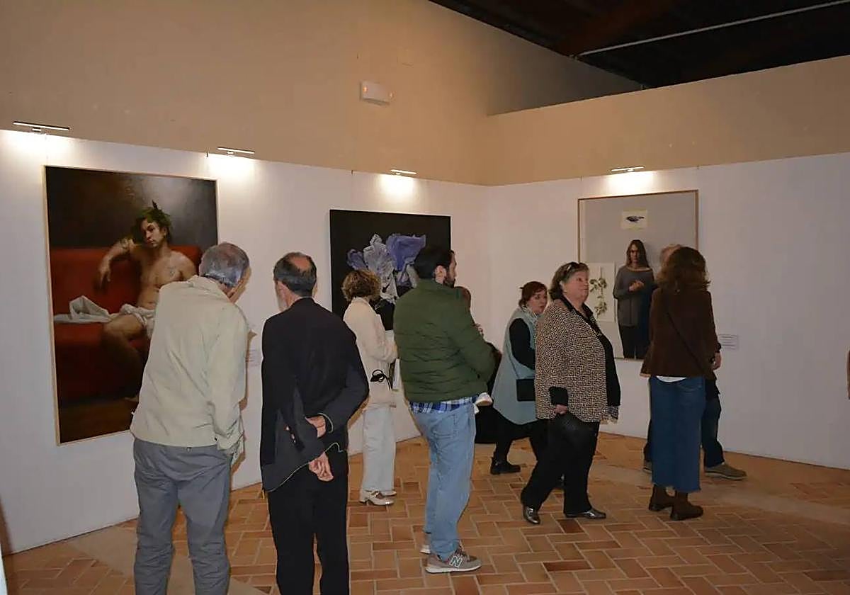 Varias personas contemplando las obras expuestas durante la inauguración.