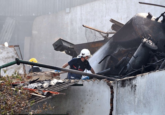 Bomberos actuando en la fábrica tras el siniestro.